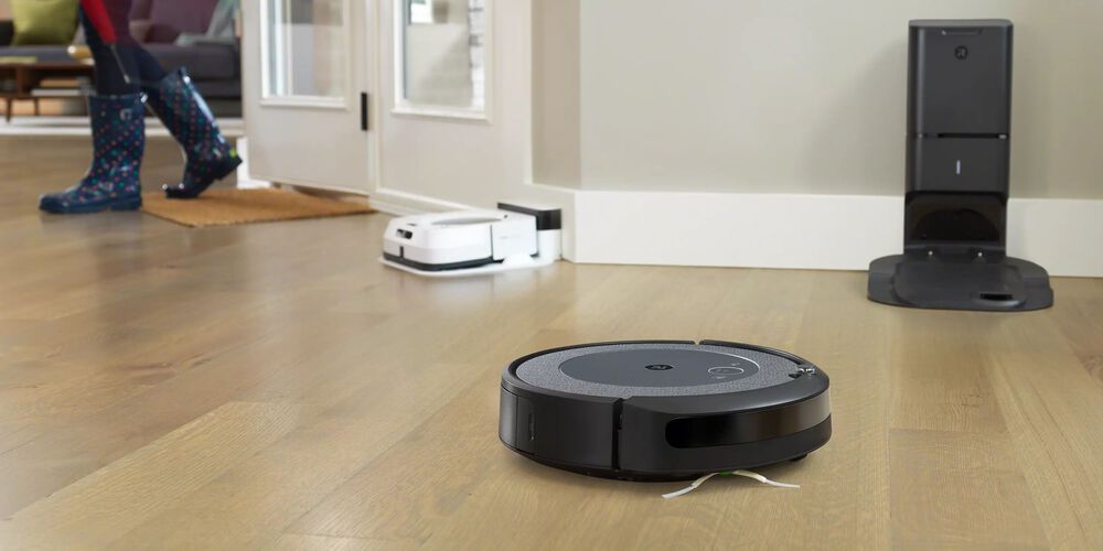 A black Roomba with a white one in the background